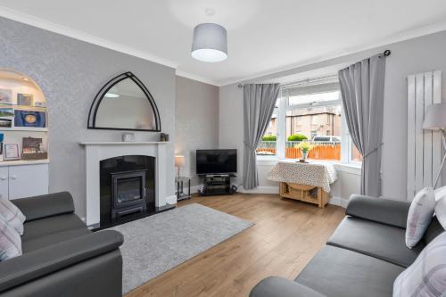 a living room with a couch and a fireplace at Crewe Apartment - Stylish 2 bedroom apt, Garden, Free parking, Edin City in Edinburgh