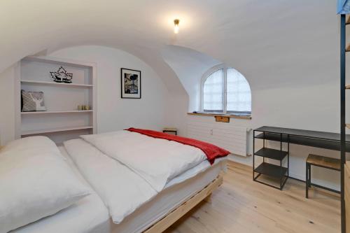 a white bedroom with a bed and a desk at Casa Pasternaria Sleeps 8 Hiking and MTB close to Laax in Sagogn