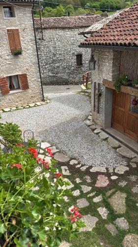 a stone building with a gate and a yard with flowers at CASA ANGELA Stayerat a SEGUSINO Valdobbiadene in Segusino