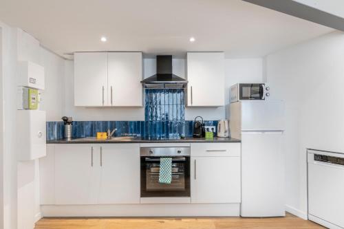 une cuisine avec des armoires blanches et un four dans l'établissement Cosy T2 in Cannes, à Cannes