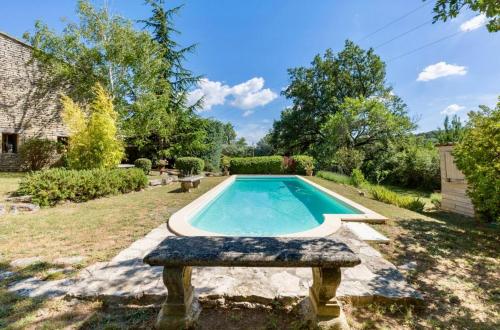 une piscine dans une cour avec un banc en pierre dans l'établissement Maison de James, à Murs