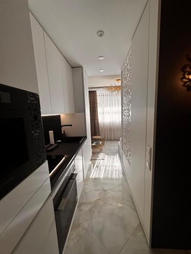 a kitchen with white cabinets and a hallway at Heaven on earth in Devin