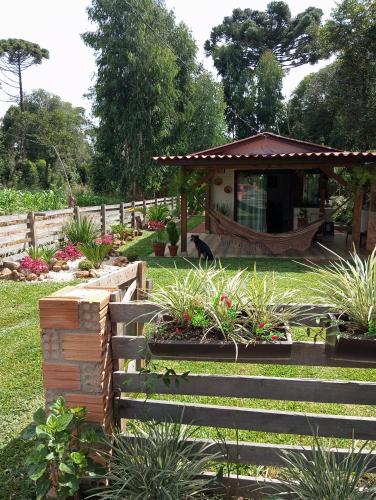 a garden with a wooden fence and a gazebo at Cantinho do Sossego in Prudentópolis
