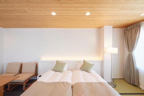 a bedroom with a large bed with a wooden ceiling at OHIO Motosan Shukuba in Takasaki