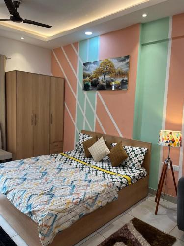 a bedroom with a bed and a painting on the wall at Coco Sunset View Luxury Suites in Noida