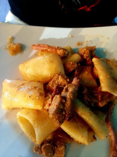 a white plate of food with meat and potatoes at Dimora Acqua del Fico in Castellabate