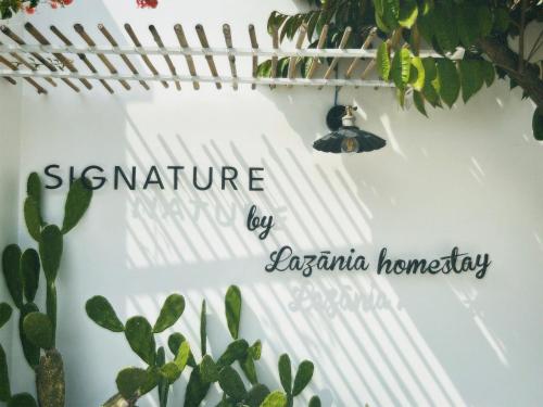 a sign on a wall with a group of plants at SIGNATURE by LAZÁNIA in Tây Ninh
