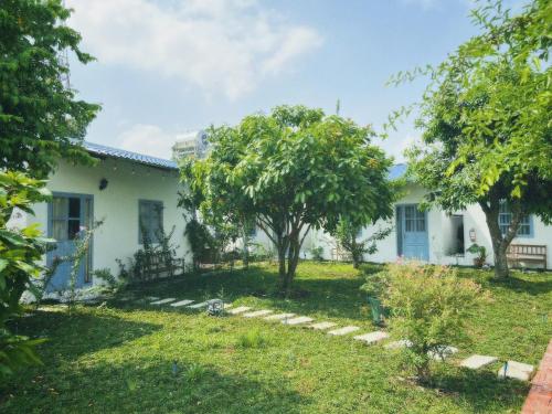 a house with a tree in the yard at SIGNATURE by LAZÁNIA in Tây Ninh