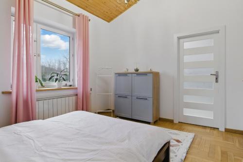a bedroom with a bed and a window at między Bugiem a Liwcem in Skuszew