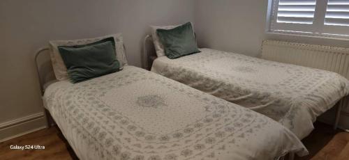 two twin beds in a room with a window at Beautiful Residential Within Easy Reach of Town in Haydock