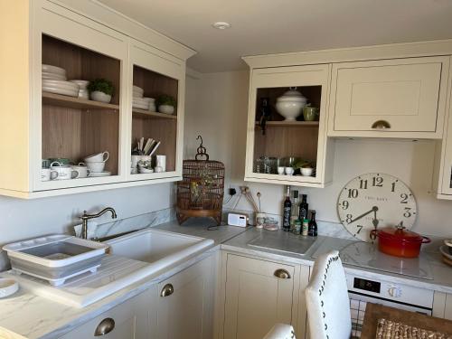 a kitchen with white cabinets and a sink at Battle Treat in Battle