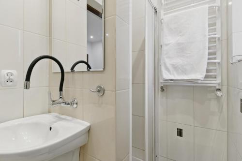 a white bathroom with a sink and a shower at między Bugiem a Liwcem in Skuszew