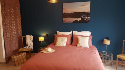 une chambre avec un lit avec un couvre-lit rose dans l'établissement gite de l'ille, à Peyriac-de-Mer