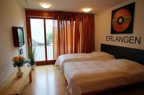 a hotel room with two beds and a television at Studio A Am Burgberg in Erlangen