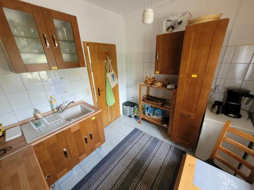 Una pequeña cocina con gabinetes de madera y un fregadero. en Altes Brauhaus Steinbach, en Steinbach