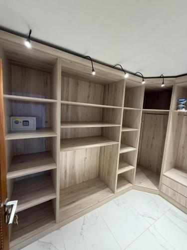 a closet with wooden shelves and lights on the wall at Ara Villa in Marrakech