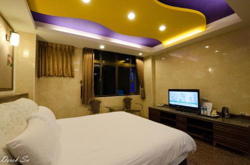ein Schlafzimmer mit Bett und Flachbildfernseher in der Unterkunft Xianfeng B&B in Hualien