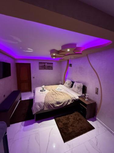 a room with a bed with purple lights on it at Ara Villa in Marrakech