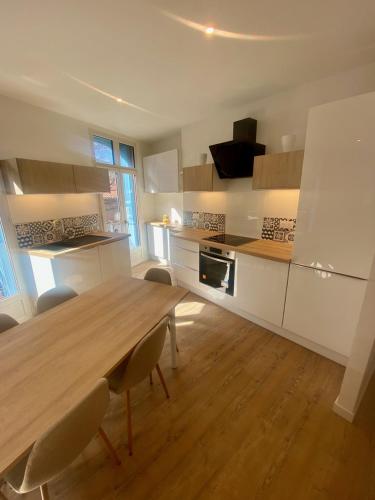 une grande cuisine avec une table et des chaises en bois dans l'établissement Le Boutigué, à Collioure