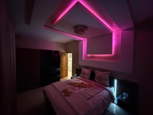 a room with a bed with a pink lighting at Ara Villa in Marrakech
