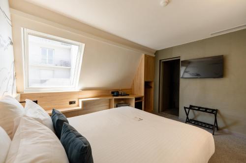 a bedroom with a white bed and a window at GREEN PARK HOTEL PARIS in Paris
