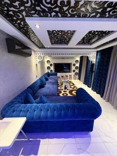 a living room with a blue couch and a television at Ara Villa in Marrakech