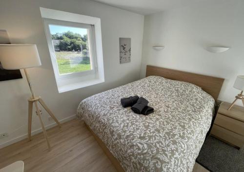 a bedroom with a bed with a pair of shoes on it at Menhirs et Moutons Ouessant in Plouëc-du-Trieux