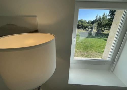 a lamp in front of a window in a room at Menhirs et Moutons Ouessant in Plouëc-du-Trieux