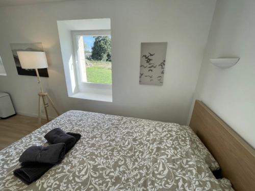 a bedroom with a bed and a window at Menhirs et Moutons Ouessant in Plouëc-du-Trieux
