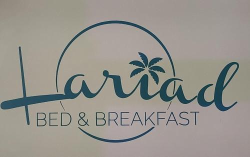 a sign for a bed and breakfast with a palm tree at Lariad BNB in Rivière Noire