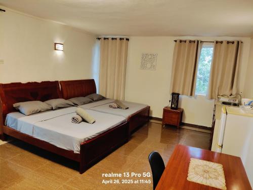 a bedroom with a large bed and a table at Lariad BNB in Rivière Noire