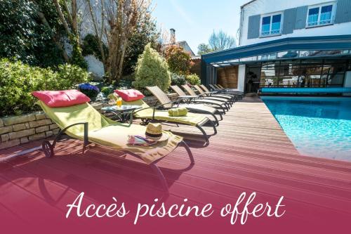 a row of lounge chairs next to a swimming pool at Hôtel de La Marée - Face à l'océan - Ile de Ré in Rivedoux-Plage