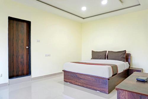 a bedroom with a bed and a desk in it at Townhouse Hotel Classy Stay in Pune