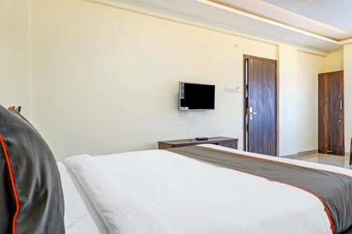 a bedroom with a bed and a tv on the wall at Townhouse Hotel Classy Stay in Pune