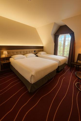 une chambre d'hôtel avec deux lits et une fenêtre dans l'établissement Domaine de La Ferrière, à Châteaubriant