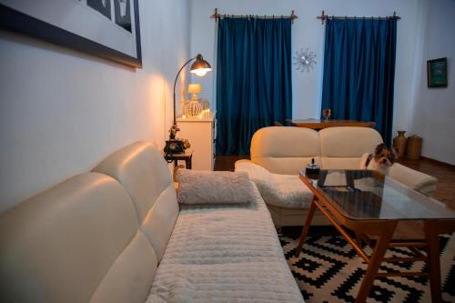 Una sala de estar con dos sofás blancos y una mesa. en Old Chadari, en Telavi