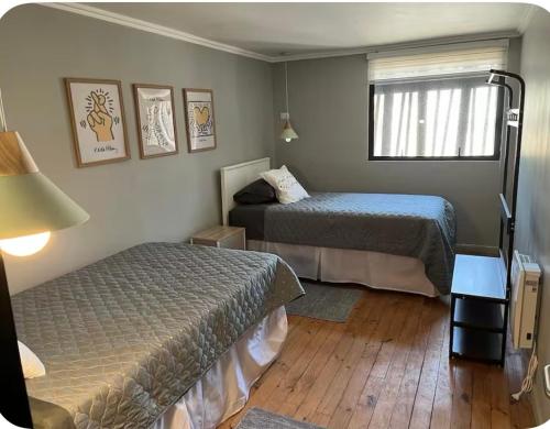 a hotel room with two beds and a window at Departamento Pacifico in Matanzas