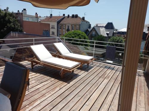 deux chaises longues sur une terrasse sur un toit dans l'établissement Appartement-terrasse parking privé Meublé de Tourisme 4 étoiles, à Belfort