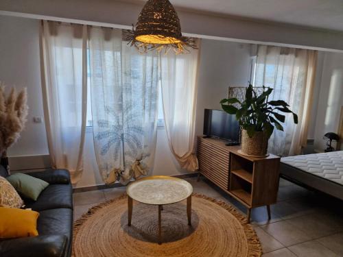 a living room with a couch and a table at Studio Le Bohème proche gare in Perpignan