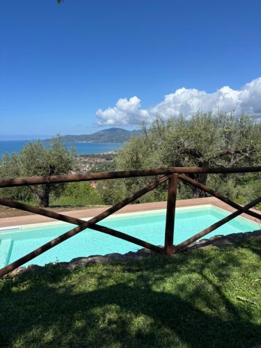 a wooden fence next to a swimming pool at Casolare Cento Ulivi Luxury & Charme in Ascea