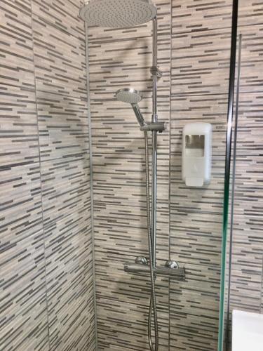 a shower in a bathroom with a tile wall at CALIFORNIA dream in Peniche