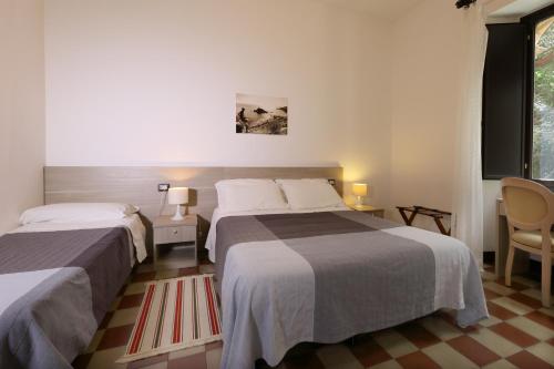 a hotel room with two beds and a window at Villa Astoria in Taormina