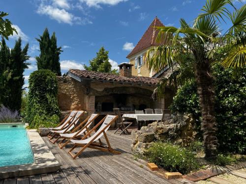 a group of chairs sitting on a deck next to a house at Propriété Le Monneton in Sainte-Christie