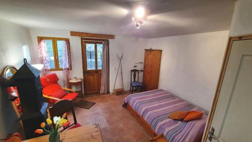 une chambre avec un lit et une chaise dedans dans l'établissement Le Petit Coeur de Cassaignes, à Cassaignes