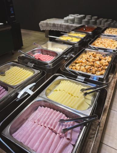 a buffet line with many different types of food at EcoMAPP Hotel in Aparecida