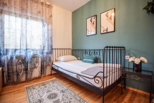 a small bedroom with a bed and a window at 6BDR Home in Nature in Sarajevo