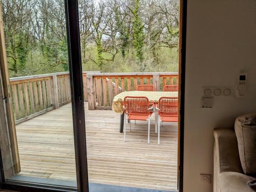 a patio with a table and chairs on a deck at Le Séchoir Pool terrace air conditioning in Cuzance
