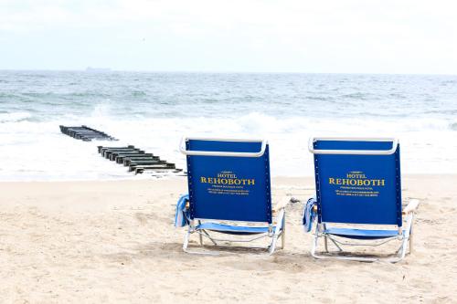 two blue beach chairs sitting on the beach at Hotel Rehoboth in Rehoboth Beach