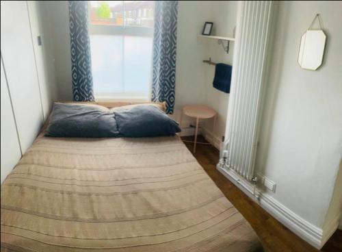 a small bed in a room with a window at Nice bedroom close to the train station and the city centre in Norwich