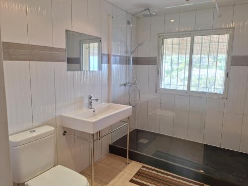 une salle de bain blanche avec un lavabo et des toilettes dans l'établissement Cannes Super Cannes Golfe-Juan - Vue mer exceptionnelle méditerranée Cap d'Antibes- Villa Alamp - 4 à 6 chambres 6 sdb 7 wc - piscine - Superbe rooftop sans vis-à-vis - grand living - Possibilité Courts séjours -, à Vallauris